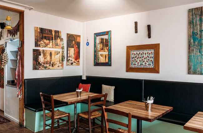 Cosy dining space in kebab shop with pops of turquoise paint and Turkish decor