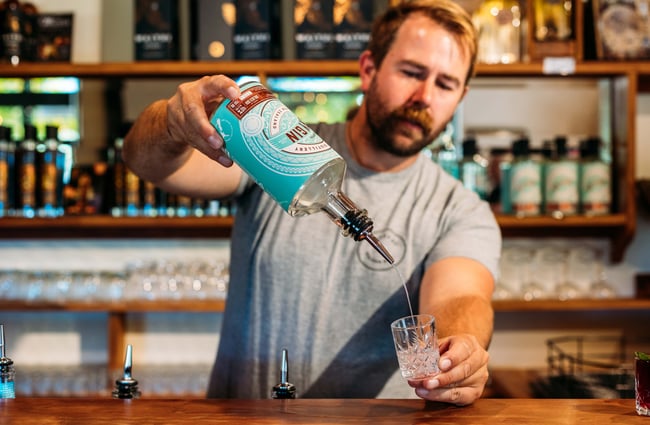 A man pouring gin into a glass.