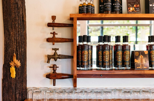 A close up of tonics and spirits on a shelf.