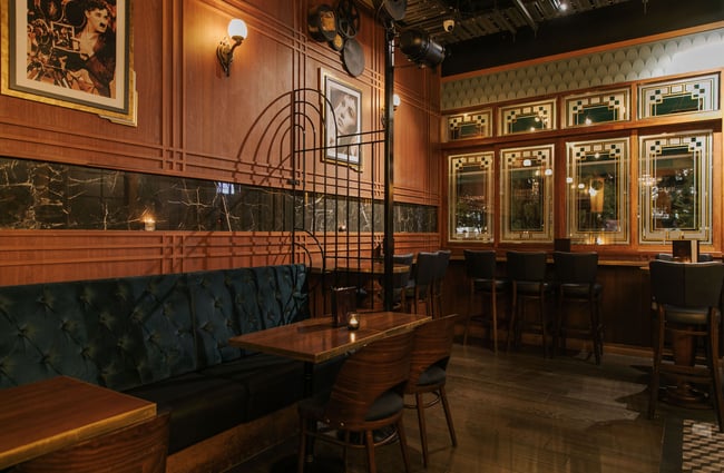 Dark wood, mirrors and soft furnishings in the interior of an art deco style bar in Christchurch