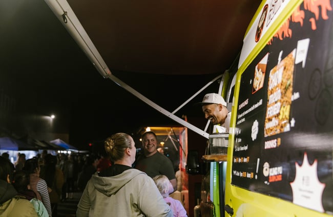 Alok laughing with customers at his food truck.