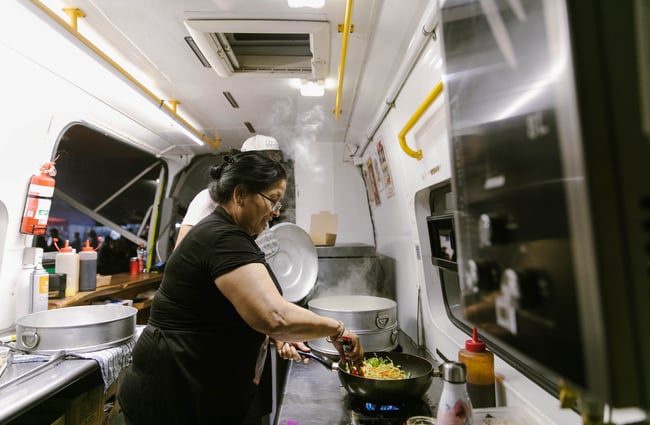 Woman making stirfry inside food truck at Kung Fu Dumplings.