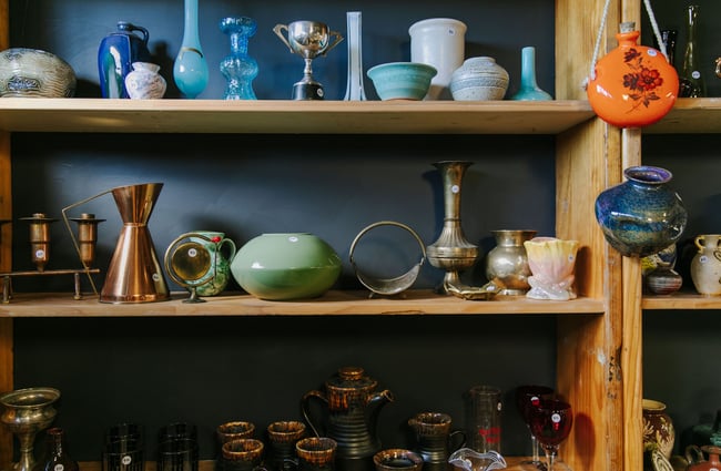 Different coloured ceramics on shelves at La Voute, Christchurch.