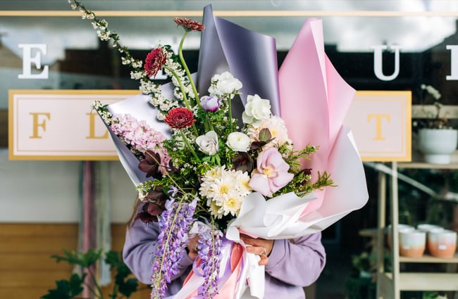 Woman holding a bouquet from Le Fleur.