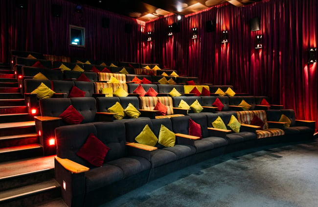 Red, blue and yellow seating inside a movie theatre.