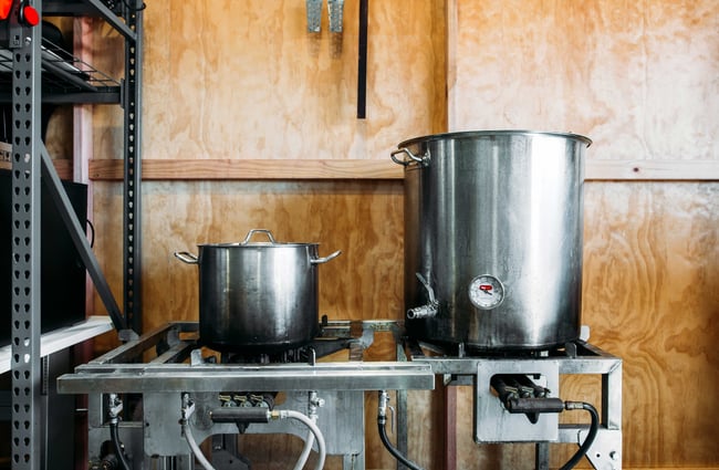 Big silver pots on gas stoves inside the Little City Kombucha workshop.