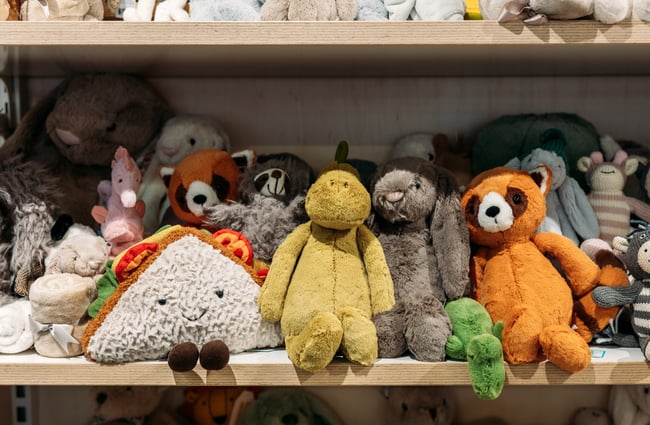 A close up of soft toys on a shelf.