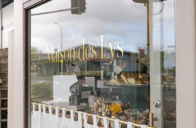 A close up of the Maison des Lys sign on a window.