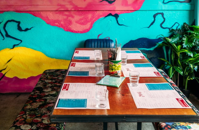 A table setting inside a colourfully decorated restaurant.