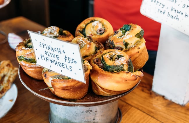 Plate of spinach olive and cheese pinwheel scrolls on cafe counter