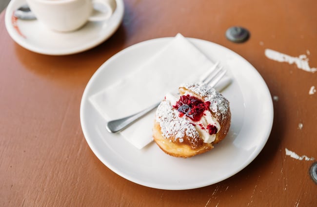 A cream-filled donut on a plate at a cafe