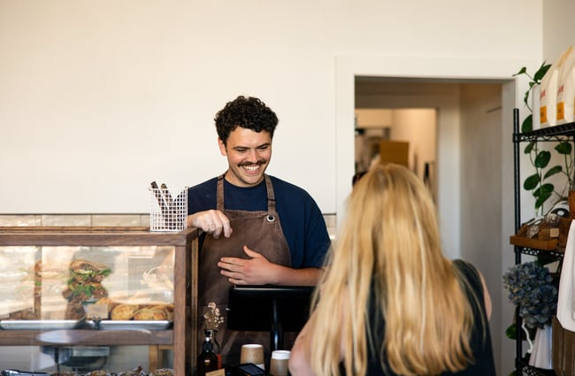 A staff member serving a customer at a cafe.