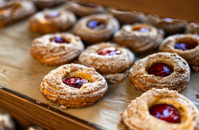 A close up of jam biscuits on a plate.