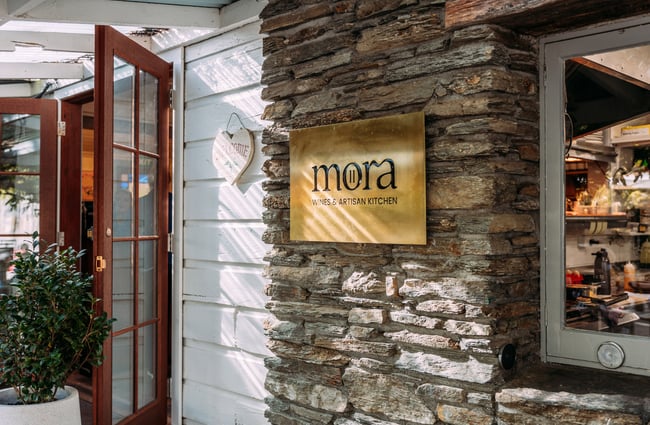 A close up of a 'Mora' sign on a building.