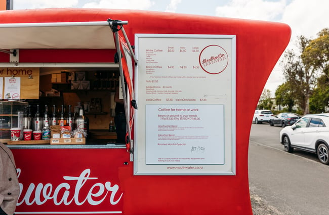 A close up of a white menu on a red caravan.