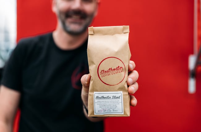A man holding a bag of coffee.