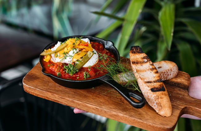 A close up of shakshuka and eggs on a platter.