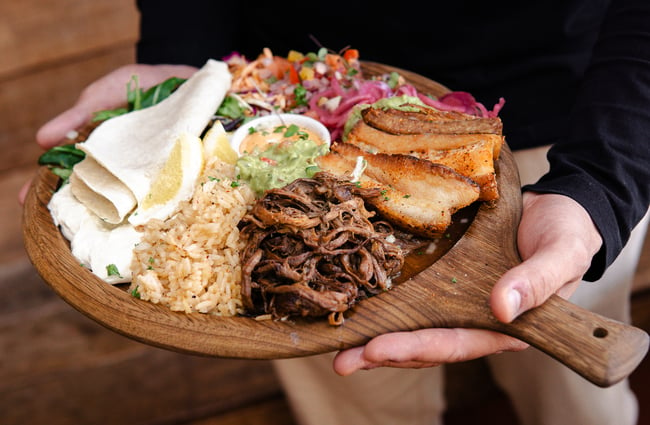 Close up of hands holding a Mexican food platter.