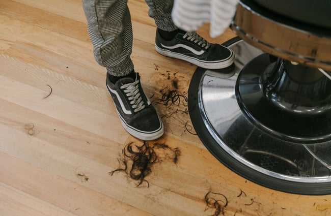 Hair clippings at a man's feet at New City Barbers in Christchurch.