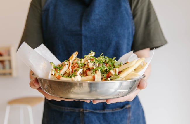 Waiter holding loaded fries at Niche Cafe and Eatery in Sumner.