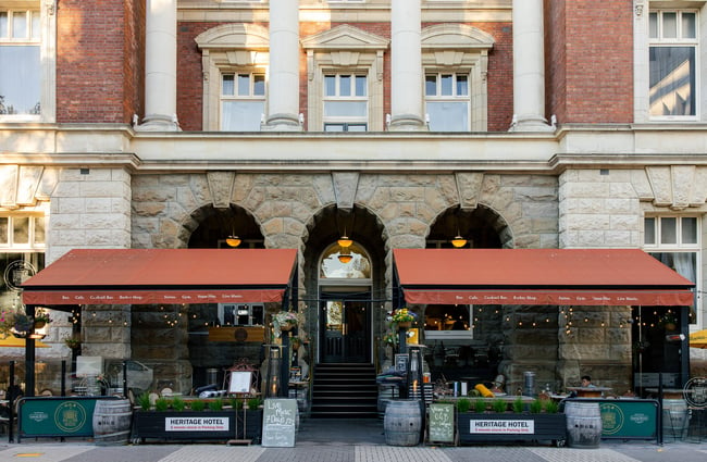 Exterior of old heritage building in Christchurch with outdoor seating at OGB bar