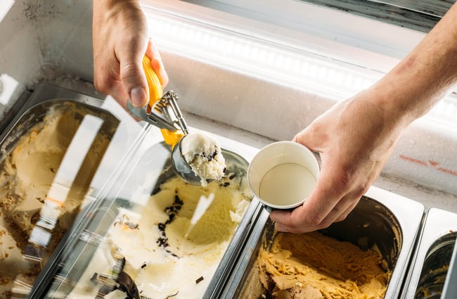 A close up of a gelato being scooped into a cup.
