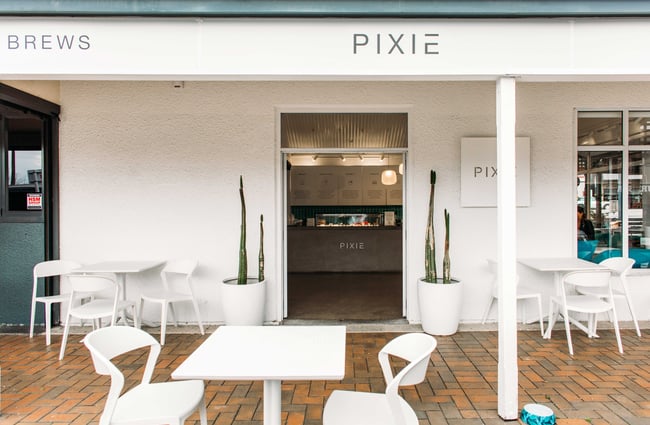 The white entrance and outdoor dining area of Pixie Bowls.