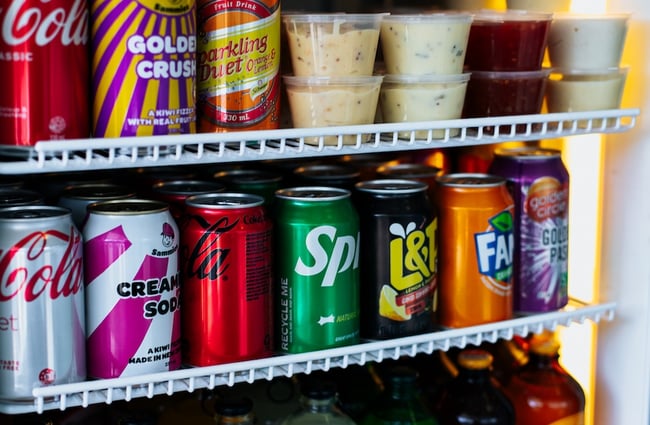 Close up of canned fizzy drinks and pottled sauces in the fridge.