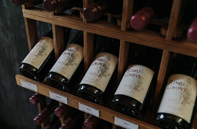 A close up of bottles of red wine lined up in a row.