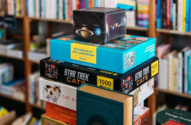 Boxes of puzzles and games stacked on top of one another in a store