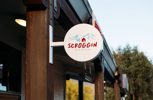 Close up of Scroggin's small, round sign mounted on a post outside.