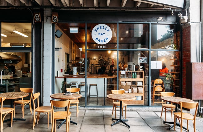 Outside area of Shelly Bay Baker on Leeds Street with wooden chairs and tables