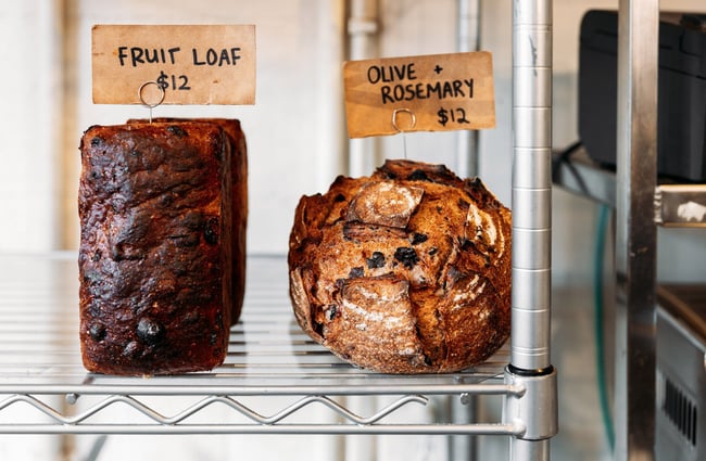 Close up of fruit loaf and olive and rosemary sourdough on shelf at Shelly Bay Baker