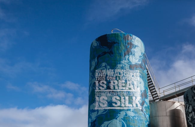 Blue silo against blue sky.
