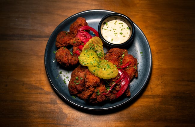 Fried chicken and pickles on a plate.