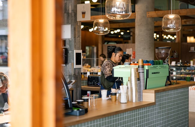 A staff member working behind a cafe counter.