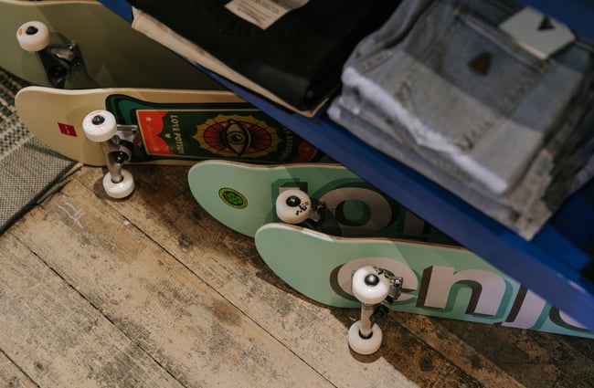 A close up of skate boards lying on their side on the wooden floor.