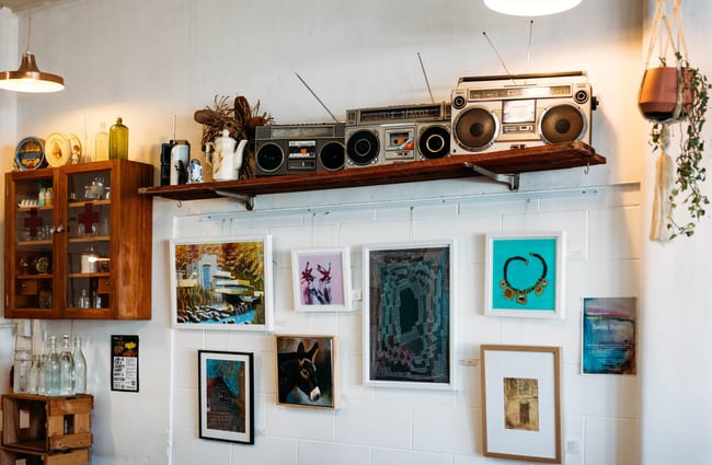 Old radios on a shelf and framed art on the wall at Space Cadet, Hamilton.