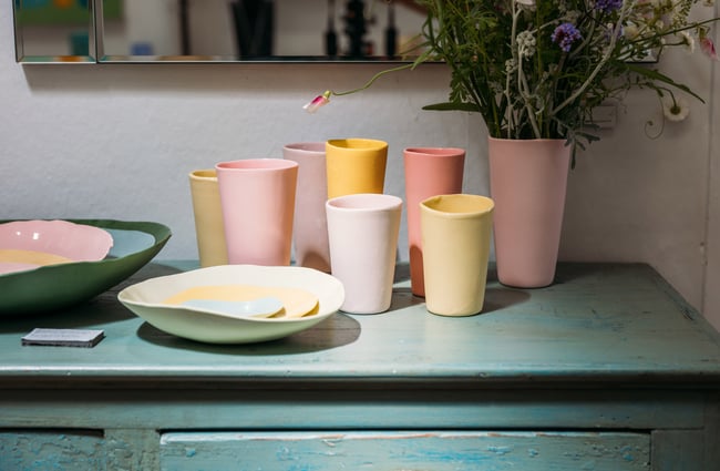 Pink and yellow cups on a table.