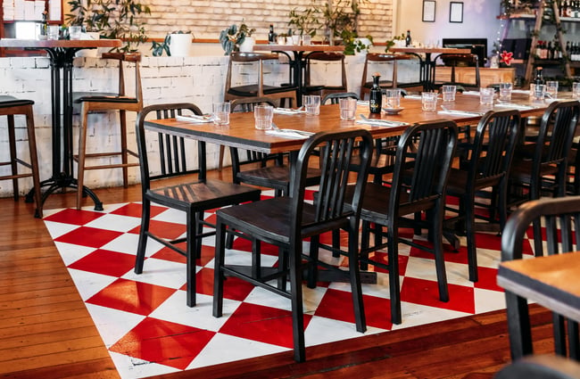 Tables and chairs on a white and red checked floor.