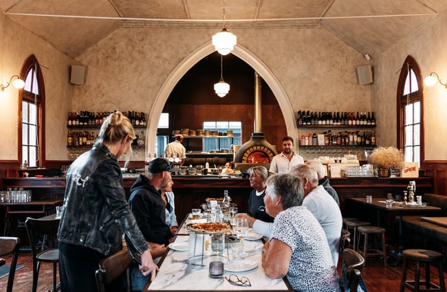 Customers dining at a large table at Sundays in Queenstown.