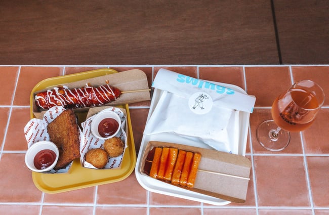 Bird eye view image of a tray of food from Swings on a tiled surface.