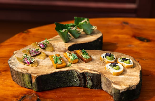 Little morsels of food on a piece of wood.