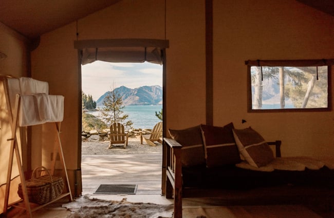 A view of a lake from inside a cabin.