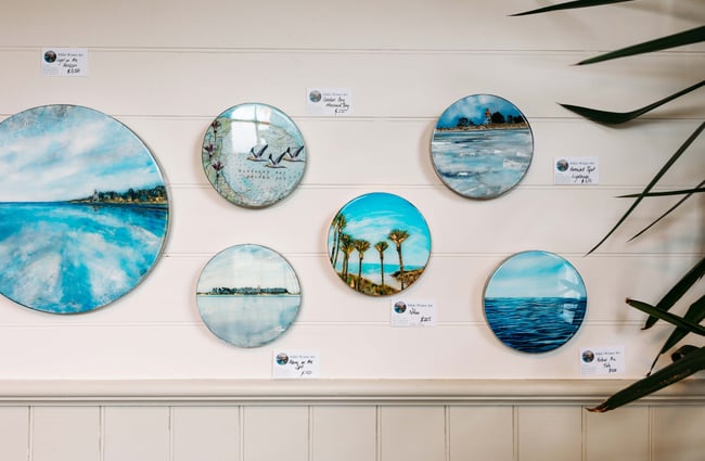 Circle works of art on a wall with landscapes.