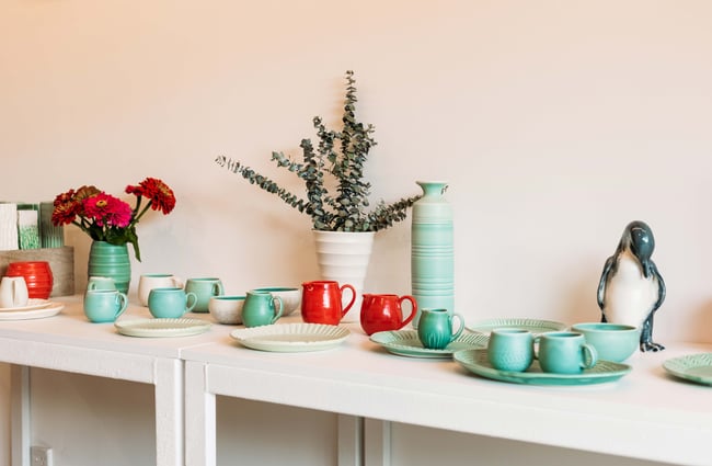 Green and red ceramics on table available to purchase.