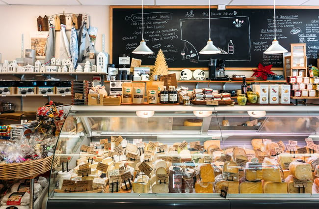 Deli full of cheeses and specialty products lined up on top