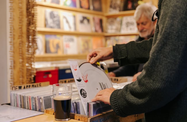 Pint of stout with man record shopping.