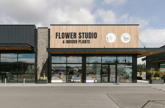 The exterior of The Green Room Flower Studio with a wooden slatted store front.