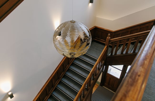 Looking down a wooden staircase with disco ball chandelier.